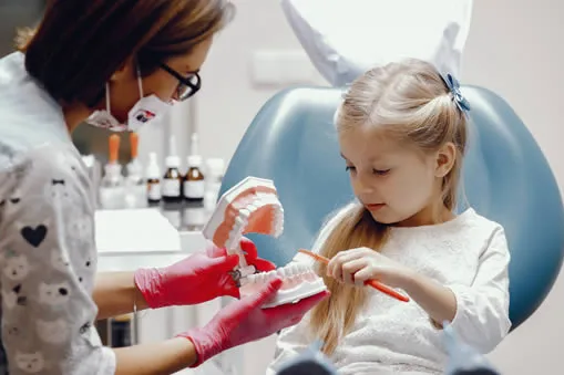 young child at dentist brushing teeth